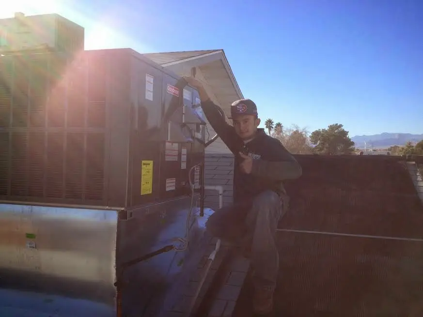 HVAC technician performing HVAC Inspection on a rooftop unit in Pikesville